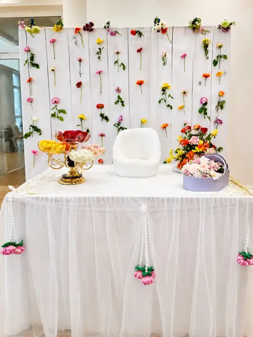 Baby Mangal Snanam naming ceremony floral setup with hanging garlands, decorated backdrop and festive table drape